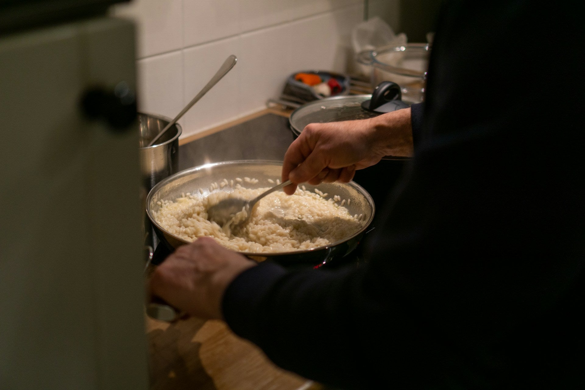 Een man roert in een pan met risotto