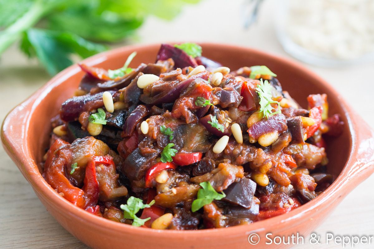 Bord met aubergine en paprika en nog andere groenten. 