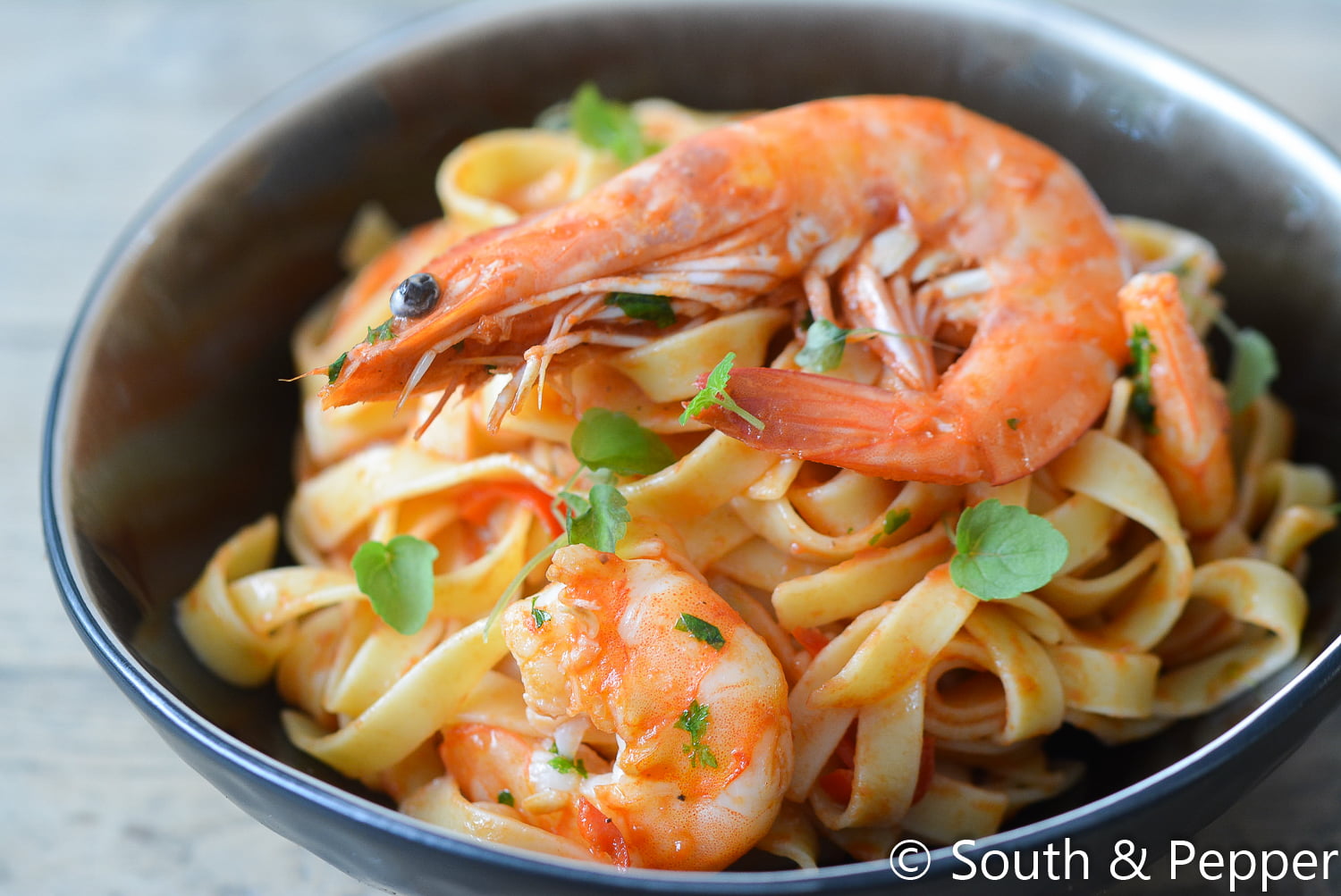 Een bord met tagliatelle en scampi