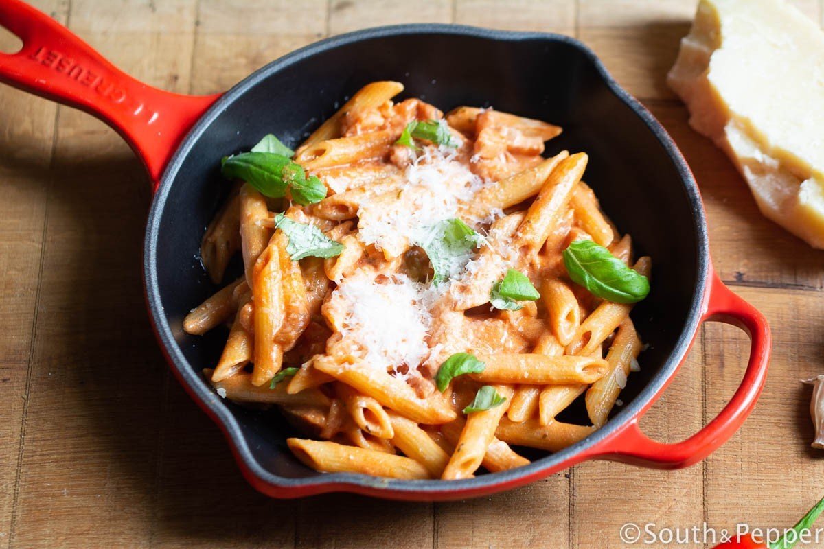 Rode pan met daarin penne met kaas, basilicum 