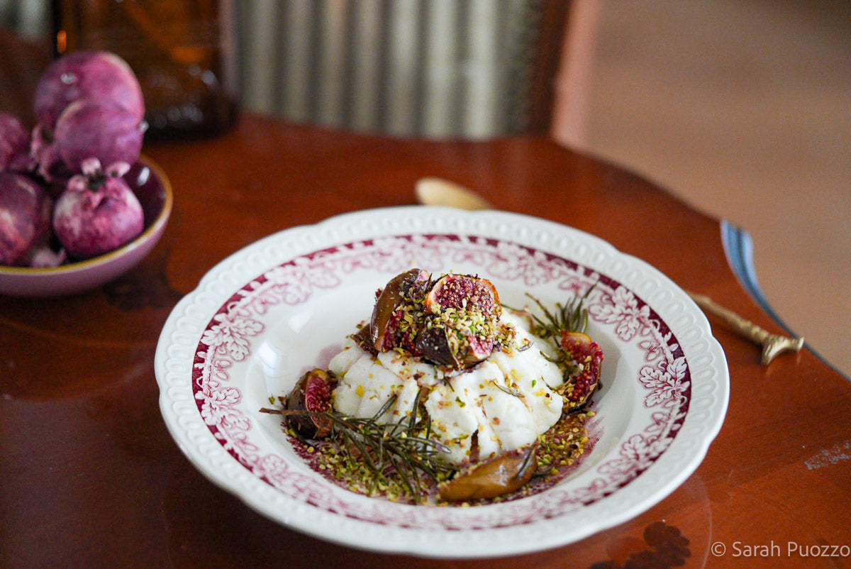 Bord met ricotta, vijgen en pistachenoten erop
