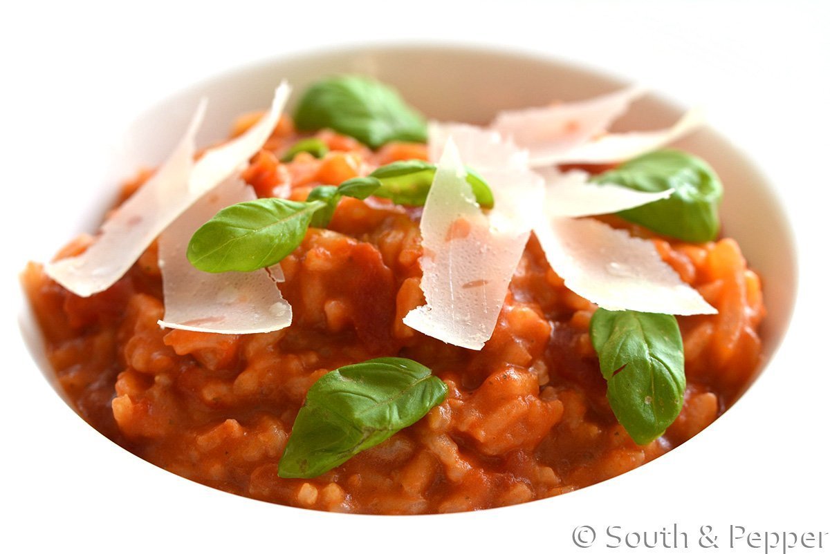 Bord met tomatenrisotto en kaas erbovenop