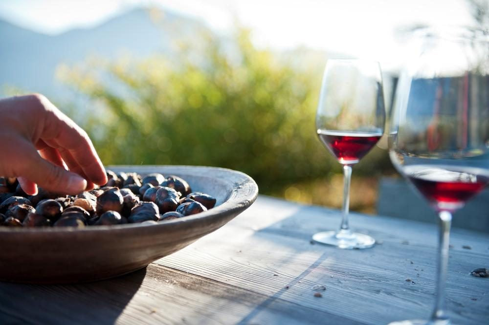 Kastanjes in een bord en twee glazen wijn
