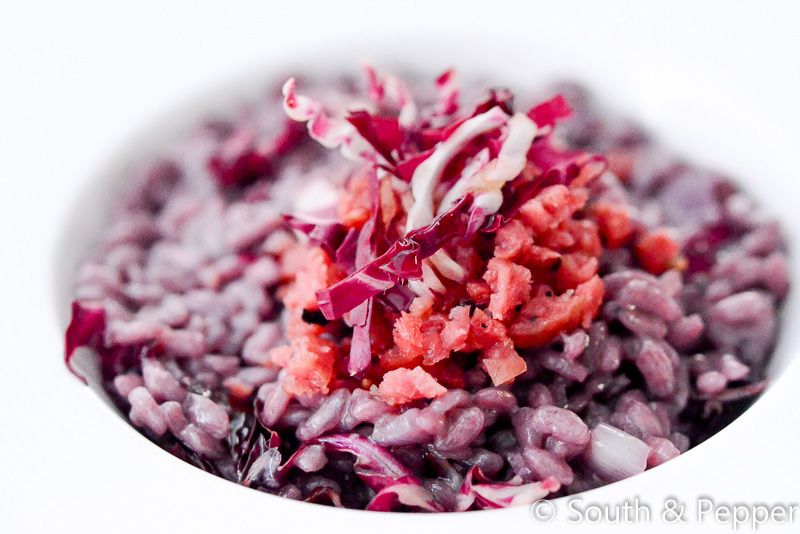 Risotto met radicchio en worst op een wit bord